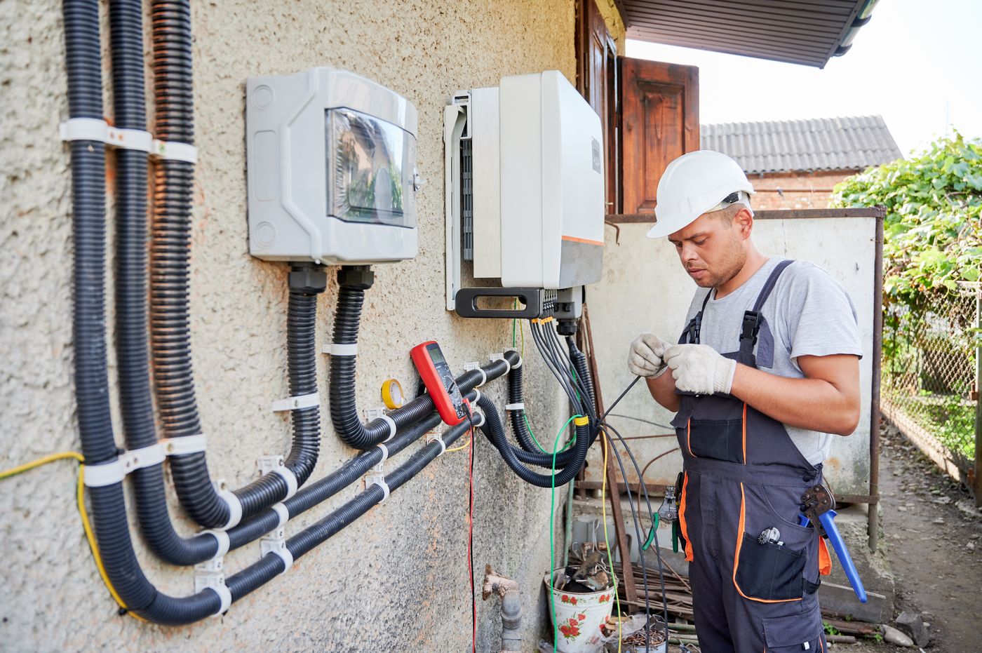 Electrician wiring and commissioning a solar inverter installation